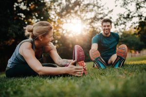 Young couple stretching outdoors in the park sports